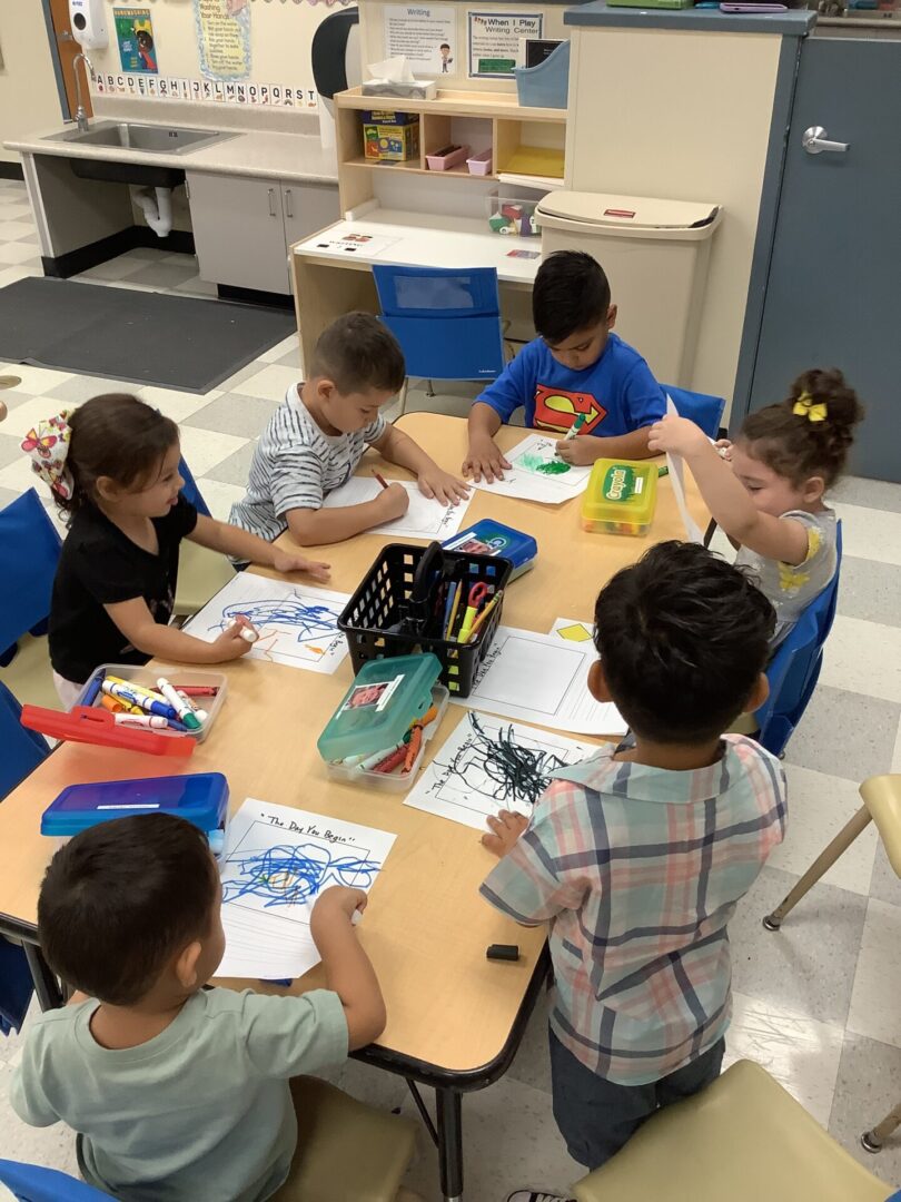 A group of children sitting at a table doing work.